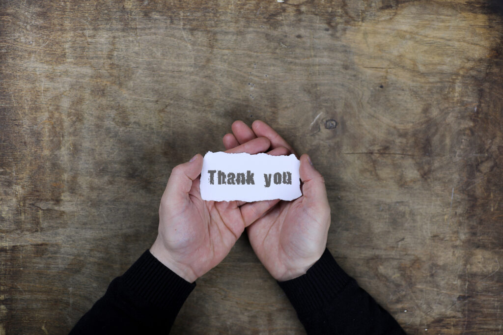 Male hands holding a white blank thank you on a sheet of paper